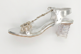 Clear high-heeled shoe with decorative elements on a white background