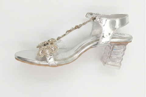 Clear high-heeled shoe with decorative elements on a white background